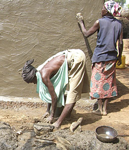 dans le village de Boundou, des femmes Kasséna préparent l'enduit qui servira de support pour la décoration de la maison