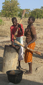 deux femmes dagara pilent des céréales près de Diébougou 